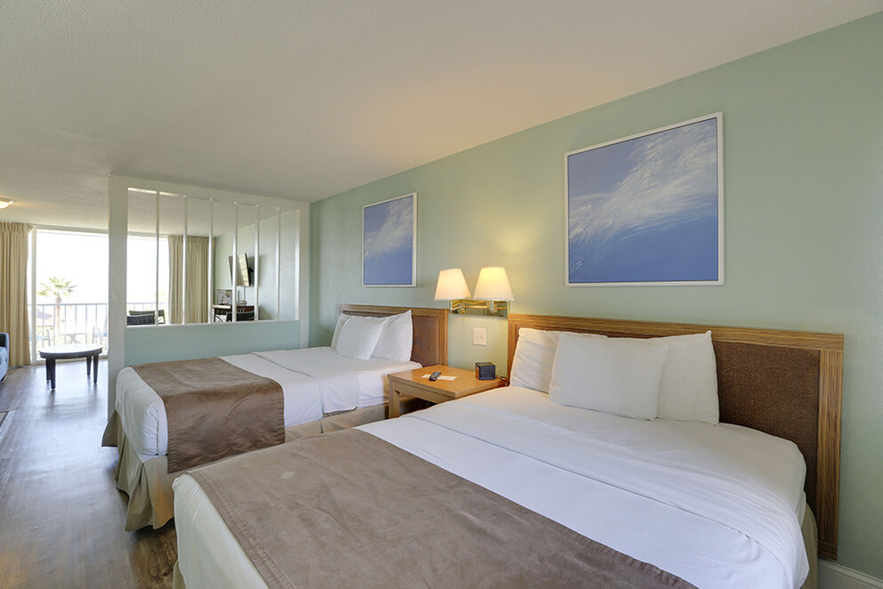 a room with two beds and a mirror