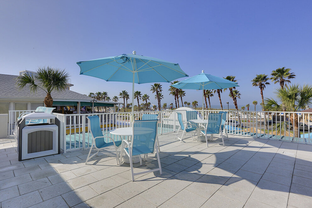a patio with blue umbrellas and chairs