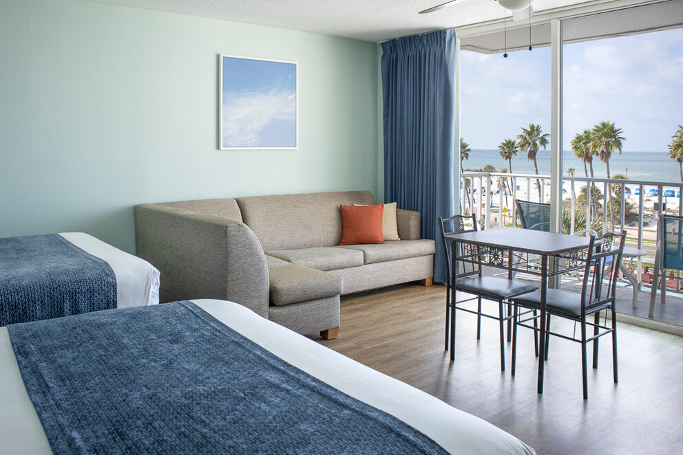 a room with two beds and a couch and a table