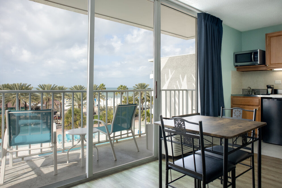 a table and chairs in a room with a balcony