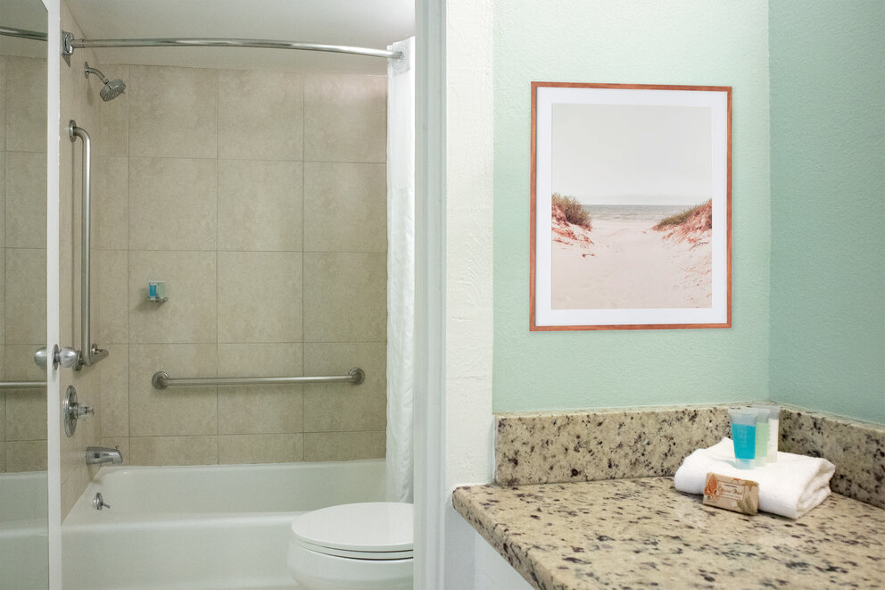 a bathroom with a marble countertop and a picture on the wall