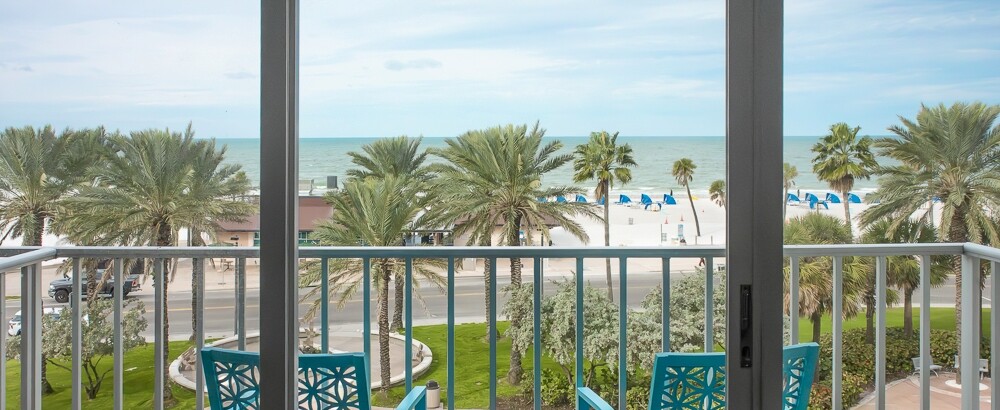 a blue chairs on a balcony overlooking a beach