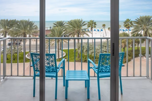 a blue chairs on a balcony overlooking a beach