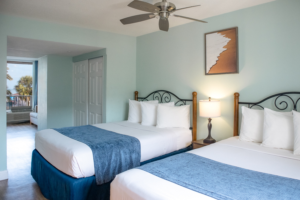 a room with two beds and a fan