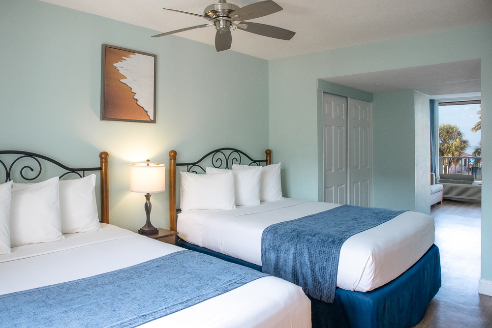 a room with two beds and a fan